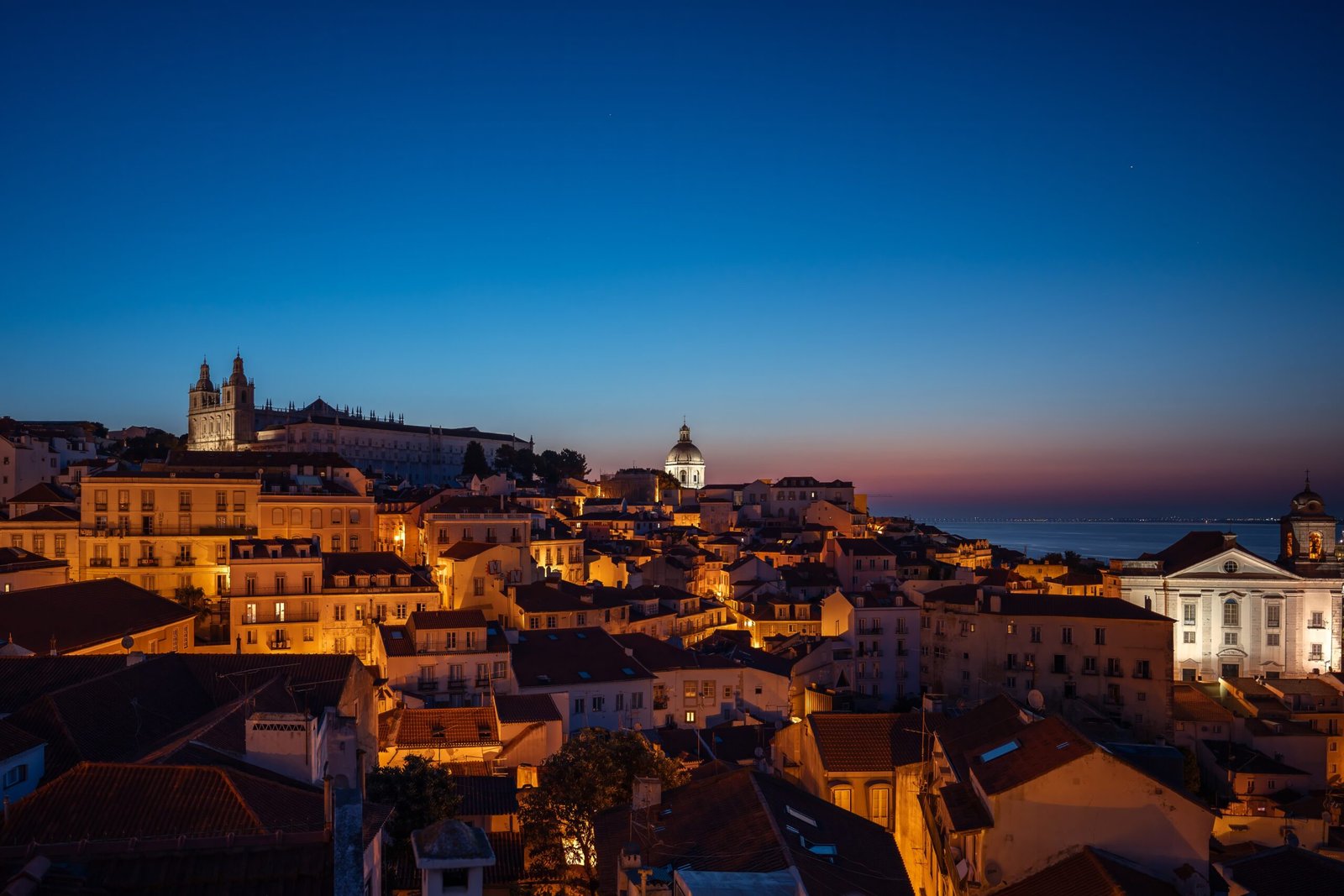 Embers of Alfama Sunset view of Alfama, Lisbon rooftops with dome and coastline – fine art photography print