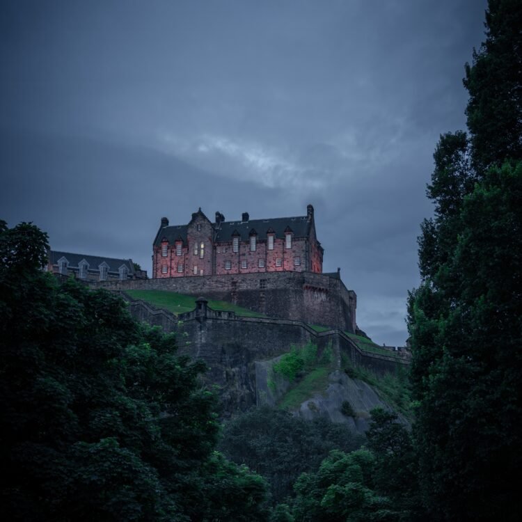 Edinburgh Castle at dusk framed by trees and dramatic sky – fine art photography print