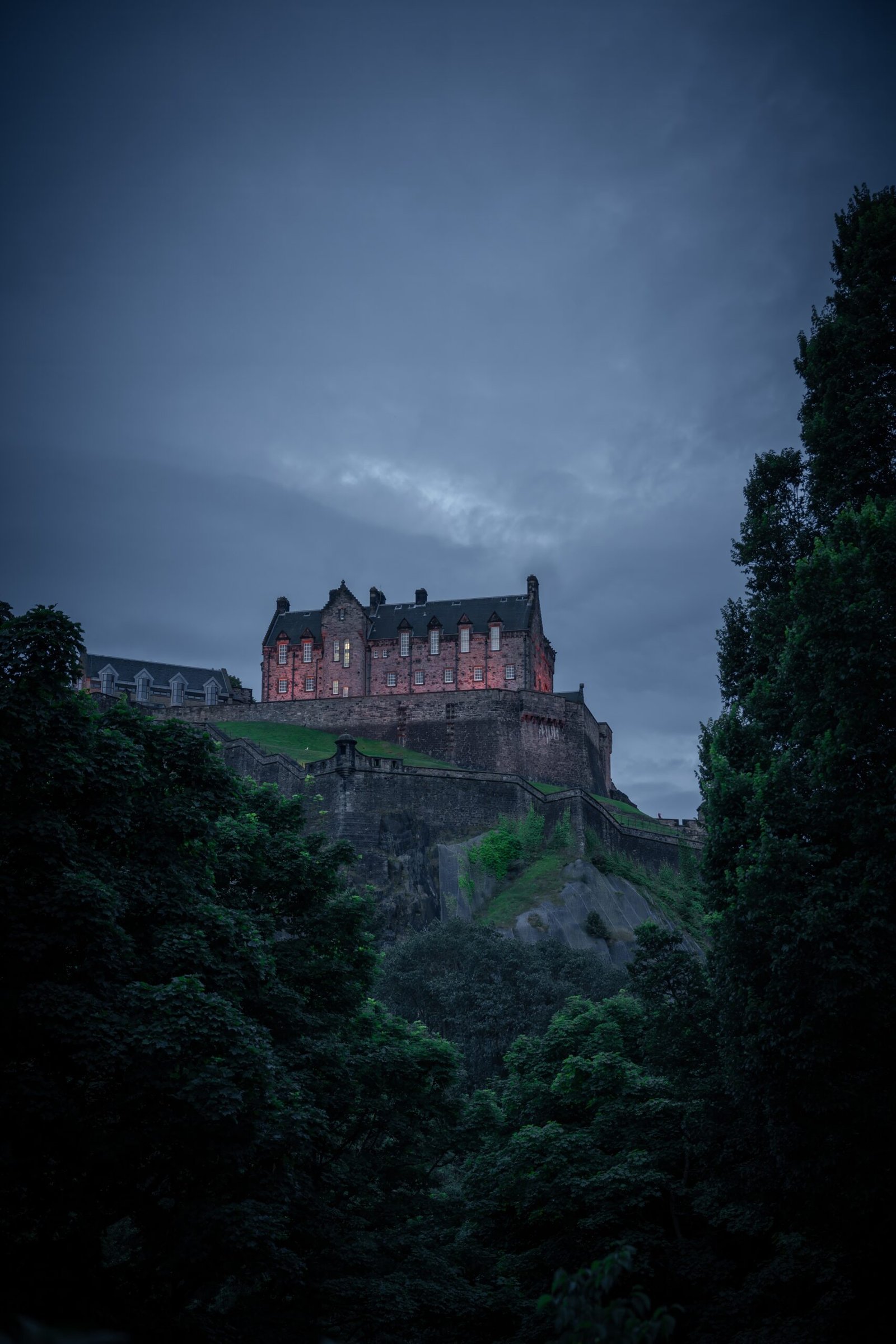Medieval Edinburgh Castle at dusk framed by trees and dramatic sky – fine art photography print