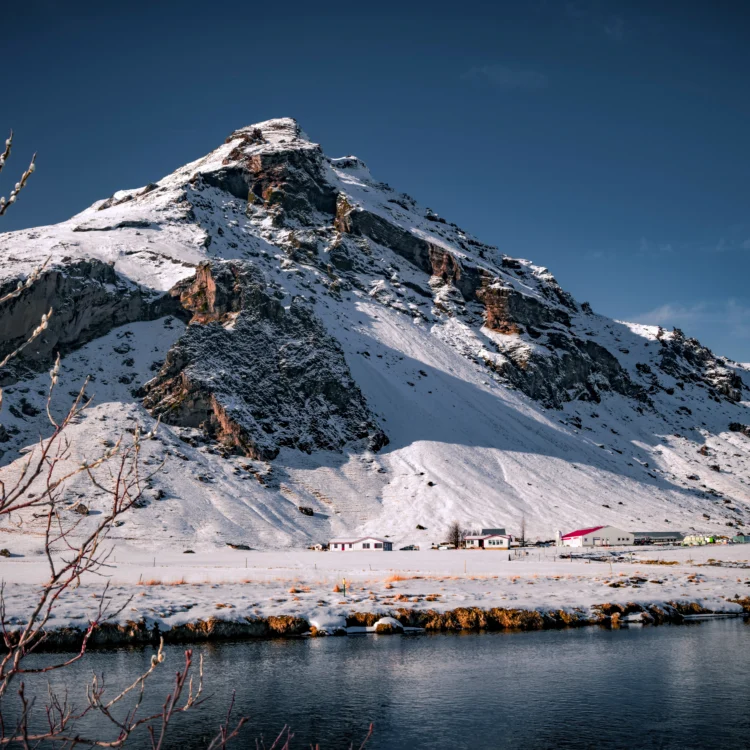 Snow-covered Skógar mountain and cottages reflected in water – Iceland winter photography print